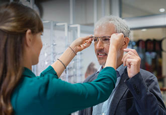 Opticienne Optic 2000 faisant essayer des lunettes à un client